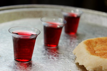 communion wine cups and bread on a tray 
