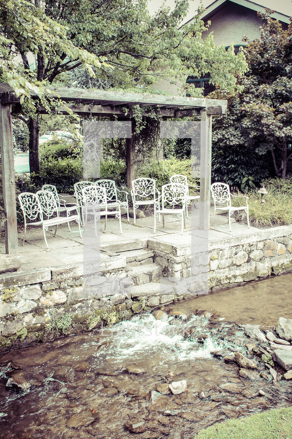 white chairs lined up in front of a brook 