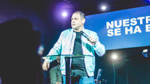 pastor on stage holding a microphone 