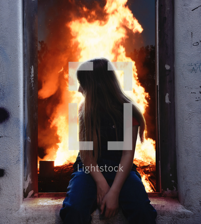 a child sitting in a window with flames behind her 