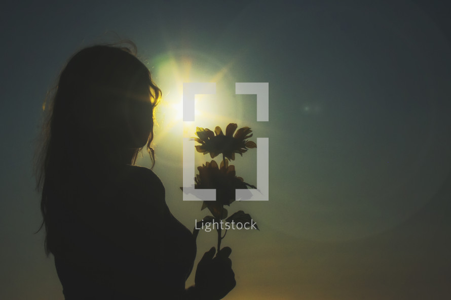 silhouette of a woman holding flowers 