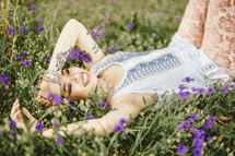 a woman lying in a field of flowers 