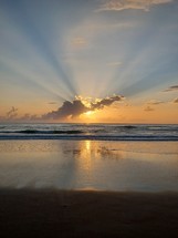 a beautiful sunrise over the ocean to start the new day with orange, purple and gray colors in the sky. 