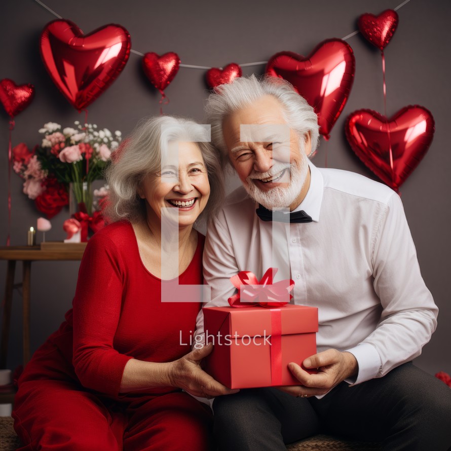Happy senior couple celebrating Valentine's day with a gift box