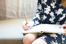 teen girl writing in a notebook 