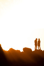 silhouettes of women standing on a mountaintop
