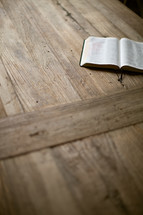 open Bible lying on a wood table 