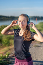 teen girl wearing headphones on a jog 