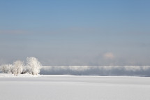 Mist and fog coming off a lake after a winter snow storm