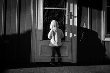 a child standing at a front door 