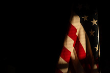 sunlight on an American flag in a dark room 