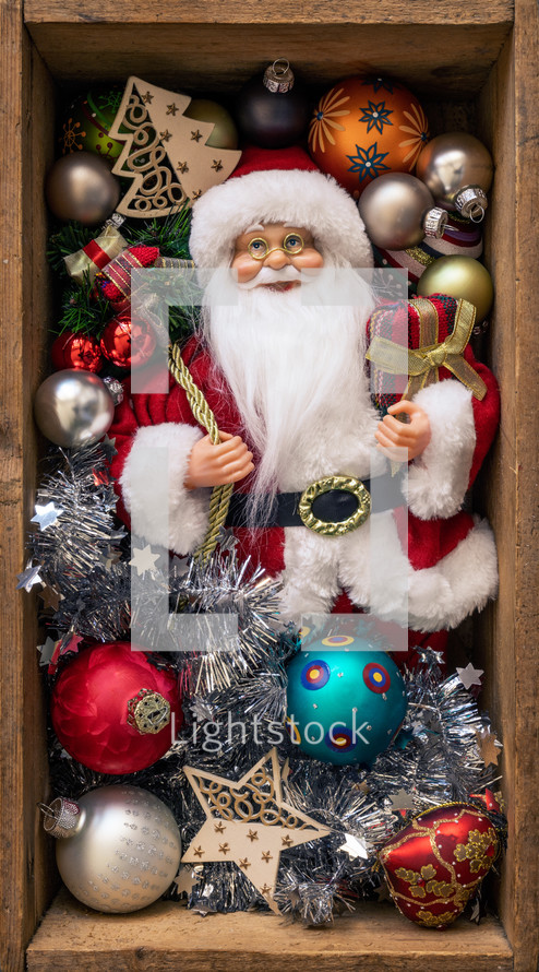 Santa figurine and ornaments in a wooden crate 