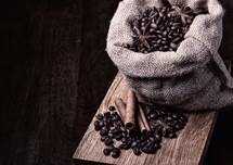bag of black coffee beans on wooden background