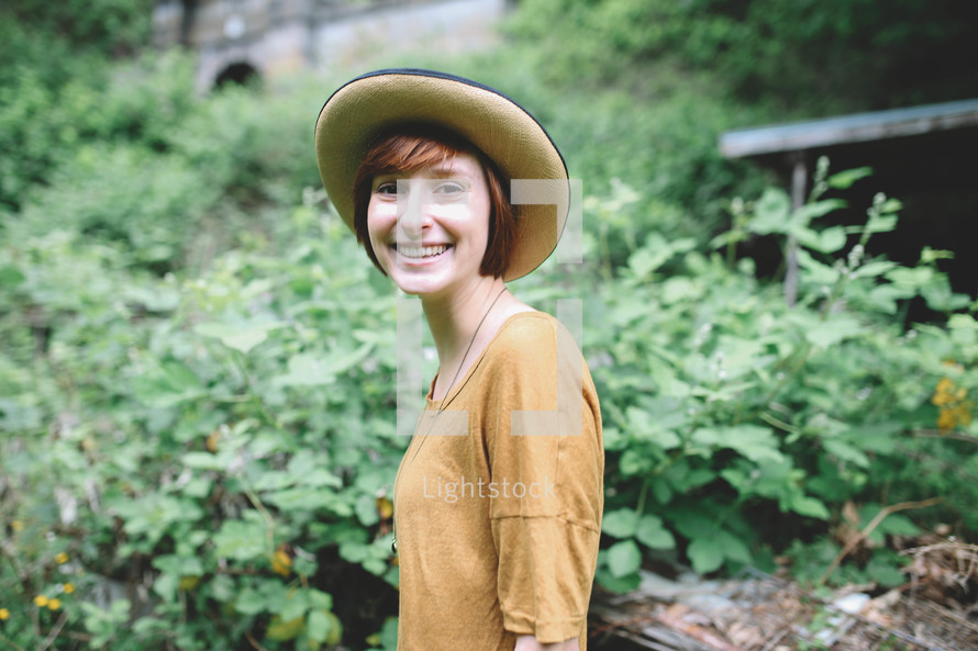 a smiling woman in a straw hat 
