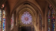 Inside view of a church with rose stained glass windows  ray of light passing trough