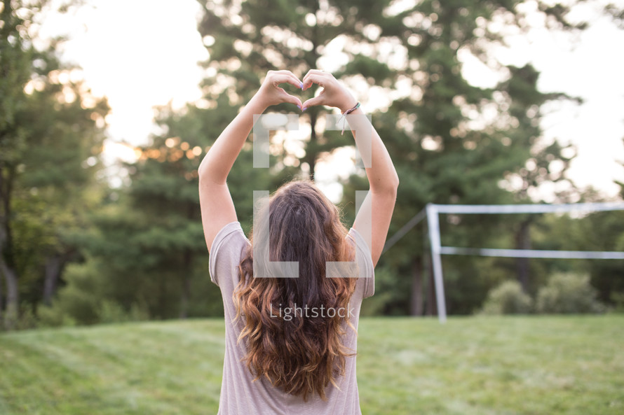 A girl forming a heart with her hands.