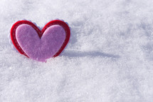 red and pink heart in snow 