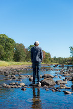 a young man standing on rocks in a river 