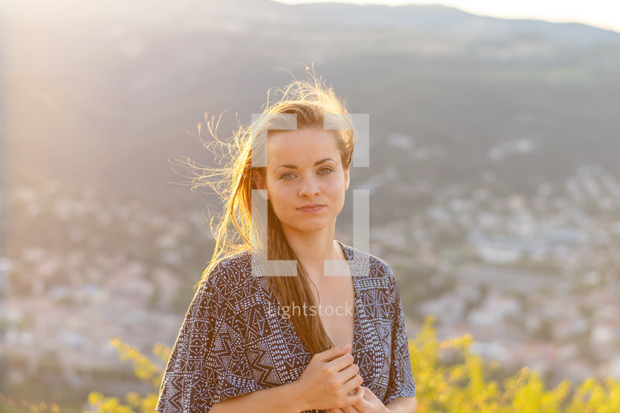 Young woman in a dress at sunset. Rhone valley in the background.