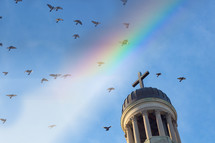 doves flying over a steeple and rainbow 