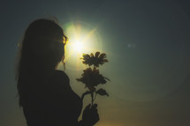 silhouette of a woman holding flowers 
