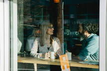 Window view of a couple having coffee in a coffee shop.