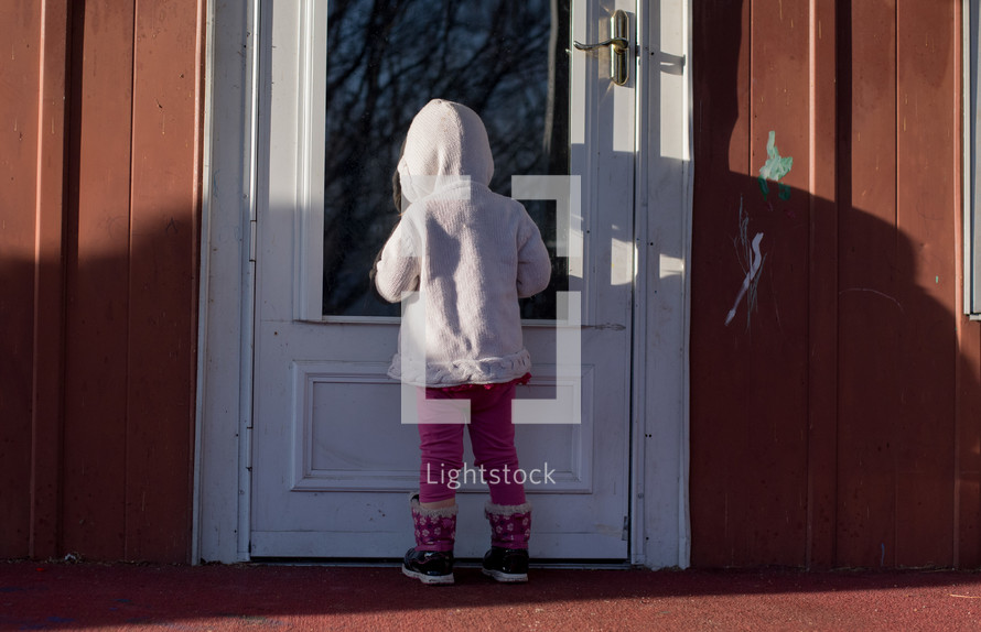a child standing in front of a door 