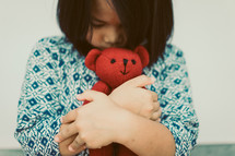 toddler hugging a teddy bear 