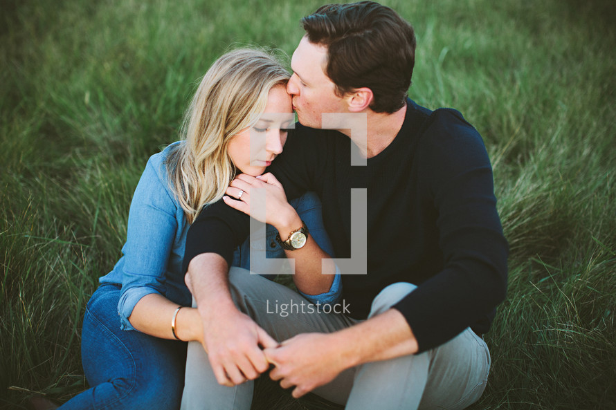 a couple sitting together in the grass