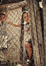 Children playing behind wire fence