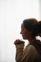 side profile of a woman praying 