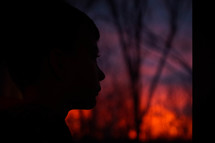 side profile silhouette of a boys face at sunset 