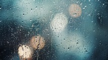 Close up view of water drops falling on glass. Rain running down on window. Rainy season, autumn. Raindrops trickle down, bokeh sky