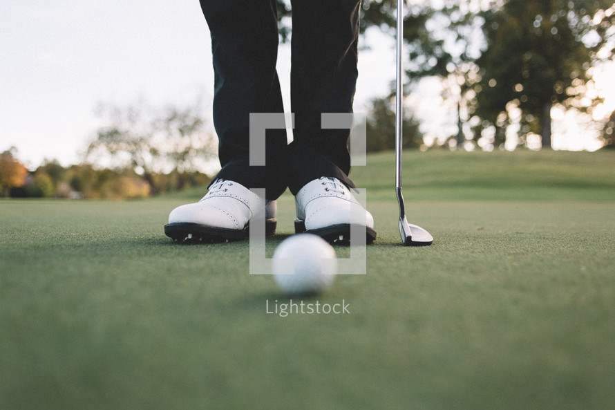 golfers feet on a putting green 