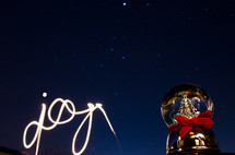joy written with light and a snow globe 