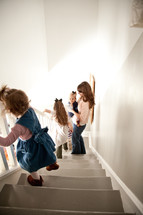 mother and children going down the stairs in their house. 