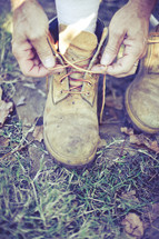man tying boots outdoors. 