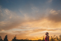 African-American woman standing outdoors at sunset 