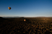 hot air balloons over a desert landscape 