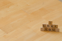 "I love you" spelled out in stacked scrabble letters.