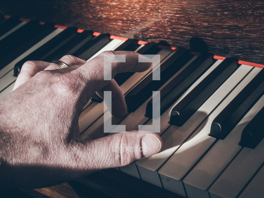a hand playing notes on a piano keyboard