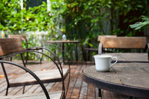 coffee mug on a wooden table outdoors 