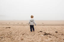 child walking in the sand on a beach 