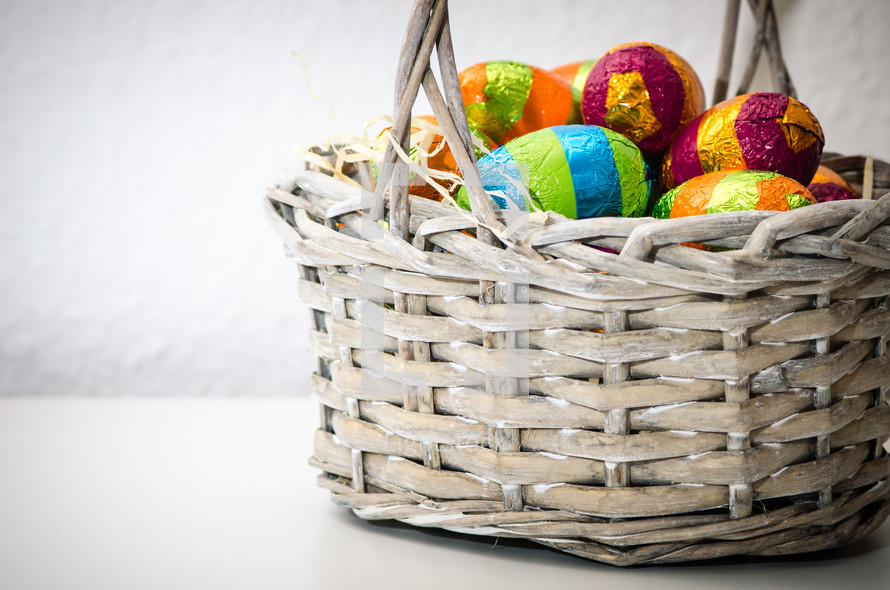 colored chocolate easter eggs in a wicker basket