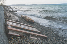 crate pallet and debris along a rocky shore 