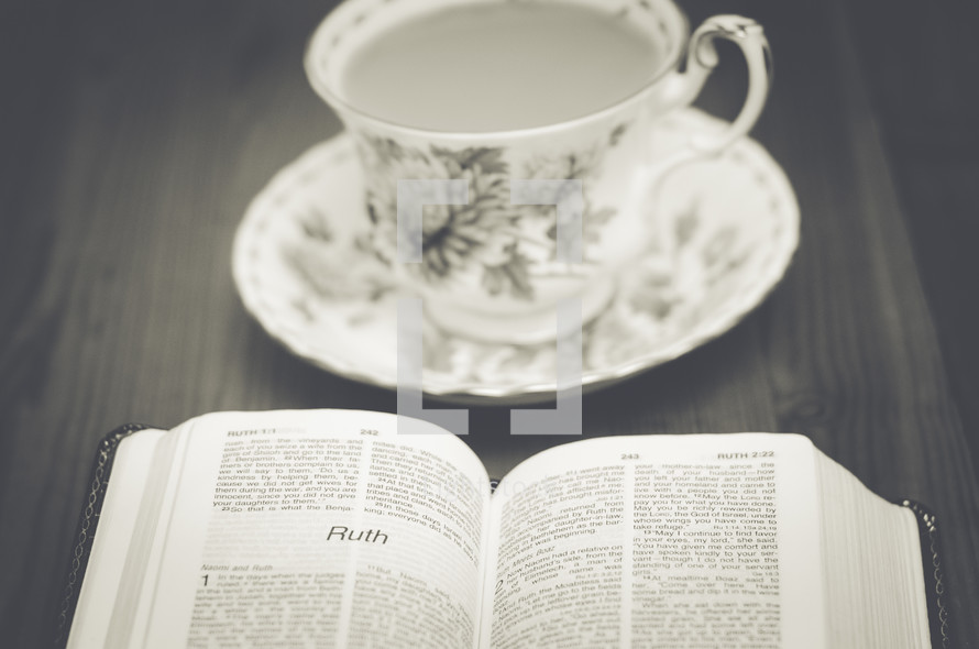 tea cup, saucer, and open Bible 