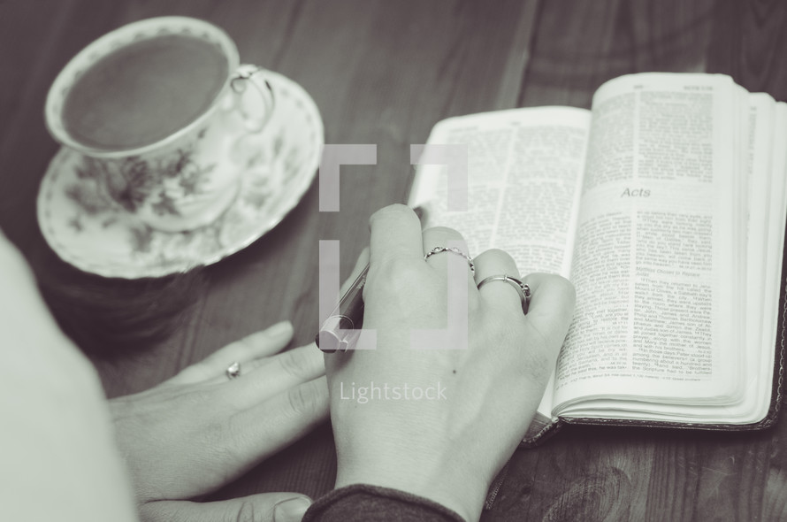 woman reading a Bible and tea cup 