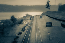 train tracks along a lake shore 