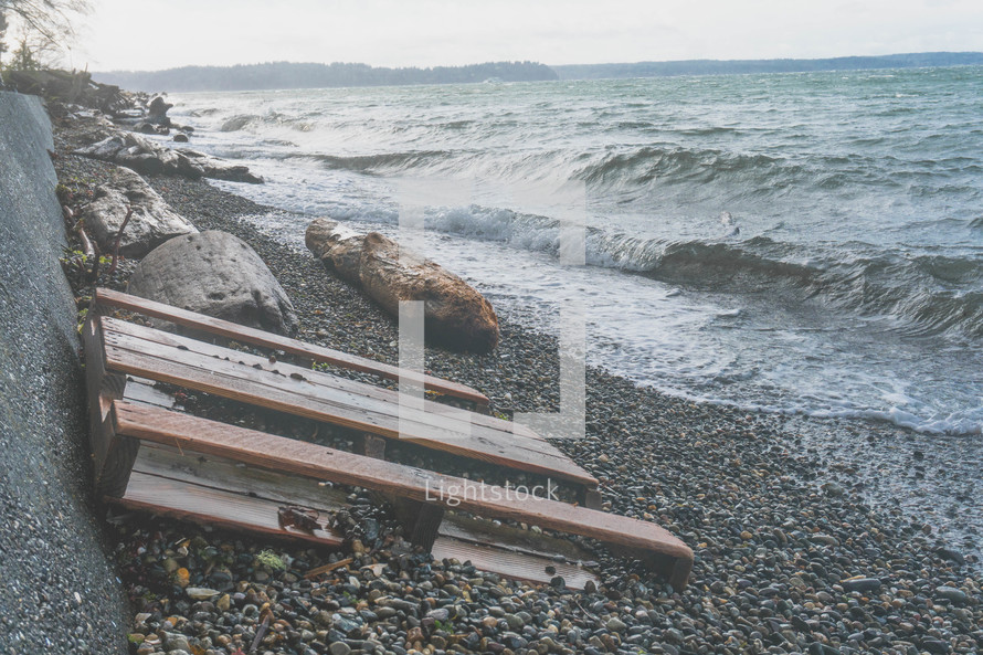 crate pallet and debris along a rocky shore 