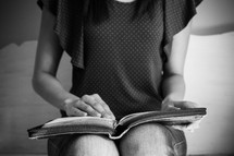a teen girl reading a Bible in her lap 